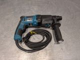 a close up of a drill on a metal surface with a cord