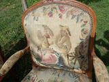 a chair that is sitting in the grass with a bird on it