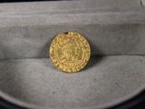 une image représentant une pièce d'or posée dans une boîte sur une table
