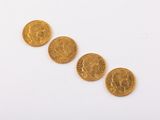 four gold coins are arranged in a row on a white surface
