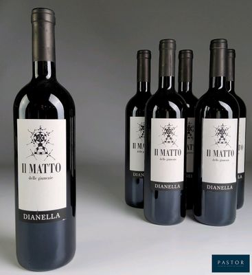 quatre bouteilles de vin rouge sont alignées sur une table