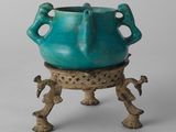 un vase bleu posé sur un socle