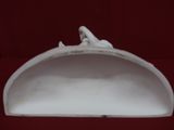 une sculpture en porcelaine blanche représentant un oiseau perché sur une étagère
