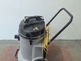 a vacuum that is sitting on the floor next to a wall