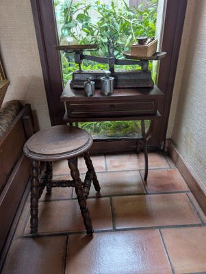 a small table and stool in the corner of a room