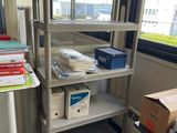 a room with a desk, shelves, and boxes on it