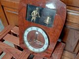 a clock that is sitting on a wooden shelf