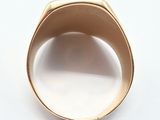 an image of a gold signet ring on a white surface