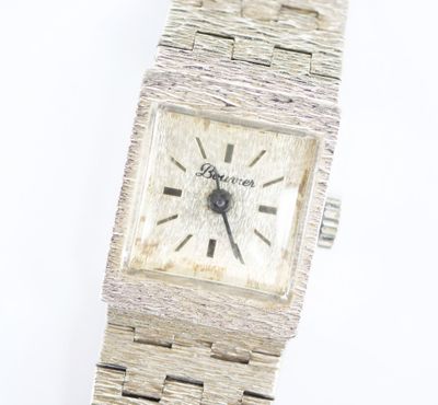 une image d'un gros plan d'une montre-bracelet sur une surface blanche