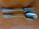 two forks and a spoon sitting on a table