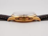 a close up of a watch on a white surface with a black strap