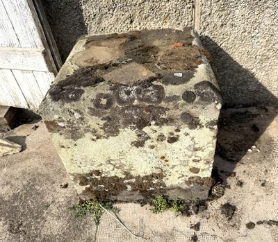 un gros rocher posé sur le trottoir, à côté d'un immeuble