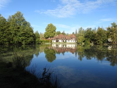 un grand étang avec une maison en arrière-plan