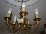 a gold chandelier with five lights hanging from the ceiling