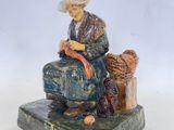 figurine représentant une femme assise sur un rocher avec un chien