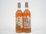 deux bouteilles de vin sont posées sur une surface blanche