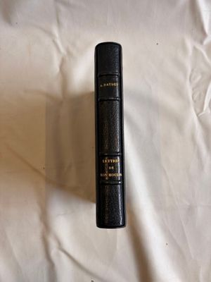 un livre noir posé sur un drap blanc, avec un stylo à l'intérieur
