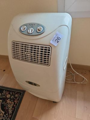 un petit climatiseur posé par terre à côté d'un tapis