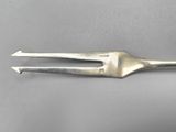 a close up of a fork on a gray surface