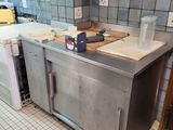 a kitchen with a stainless steel counter top and a tile floor