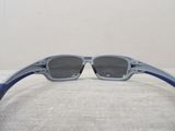 oakley sunglasses with blue arms and gray lenses laying on a white surface