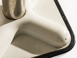 a white sink with a metal faucet on it