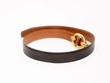 un gros plan sur une ceinture noire et marron dotée d'une boucle dorée