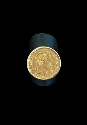 gros plan d'une pièce d'or sur une surface noire