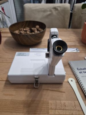 un appareil photo posé sur une table à côté d'un bol de noix