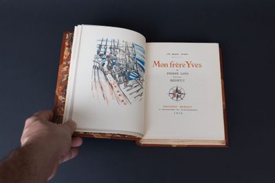 une personne tenant un livre ouvert sur une table