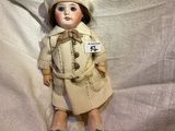 a doll that is laying down on a white sheet