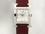 a close up of a watch on a white surface with a red strap