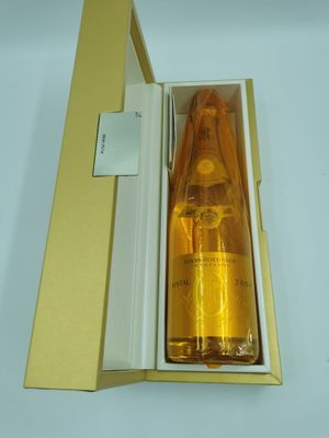 une bouteille de liquide posée dans une boîte sur une table