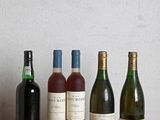 plusieurs bouteilles de vin sont alignées sur une table en bois