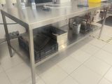 a large stainless steel table with a bunch of items on it