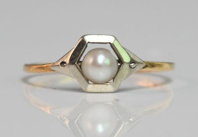 a close up of a ring with a pearl in it