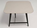 une table blanche avec des pieds noirs et un plateau blanc