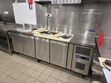 une cuisine équipée de plans de travail et d'appareils électroménagers en acier inoxydable