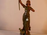 une statue représentant une femme tenant une épée, posée sur une table