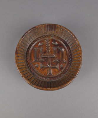 une image représentant une assiette en bois ornée d'un motif