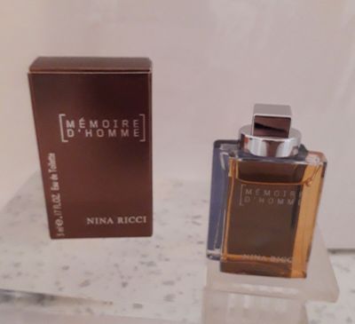 un flacon de parfum posé sur une table à côté d'une boîte
