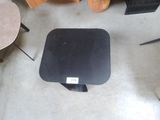 a black table with a black top and a black chair in the background