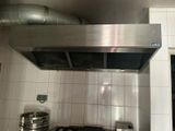 une plaque de cuisson en acier inoxydable dans une cuisine carrelée de blanc