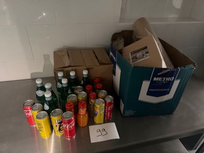 boxes of sodas and cans on a metal table in a kitchen