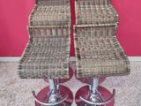pair of wicker bar stools with chrome base and foot rest