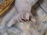 a figurine of a baby holding a banana in its hand