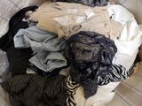 a pile of clothes sitting on top of a bed