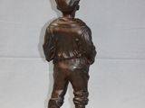 bronze statue of a boy with a hat and a baseball uniform