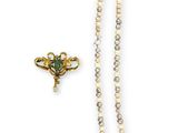 a close up of a necklace and a broocher on a white background