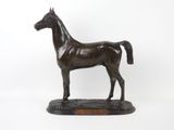 statue d'un cheval debout sur un socle en bois sur fond blanc